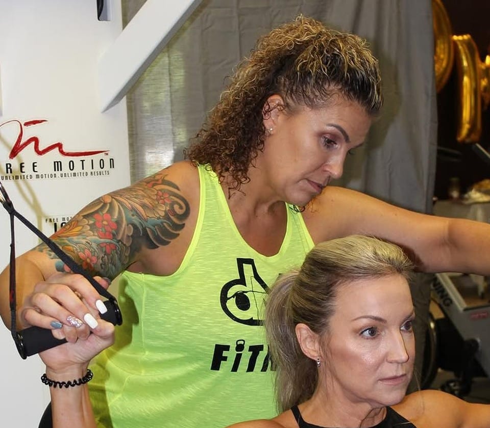 Dulcie Palmer coaching a client through an upper-body strength exercise